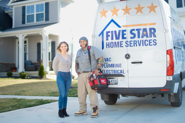 Homeowner with a Five Star Home Services plumber after installing a whole house backwashing carbon filter.