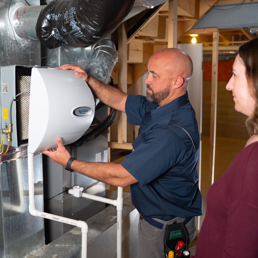 hvac tech showing a homeowner their humidifier