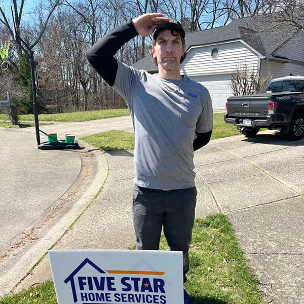tech saluting with a yard sign