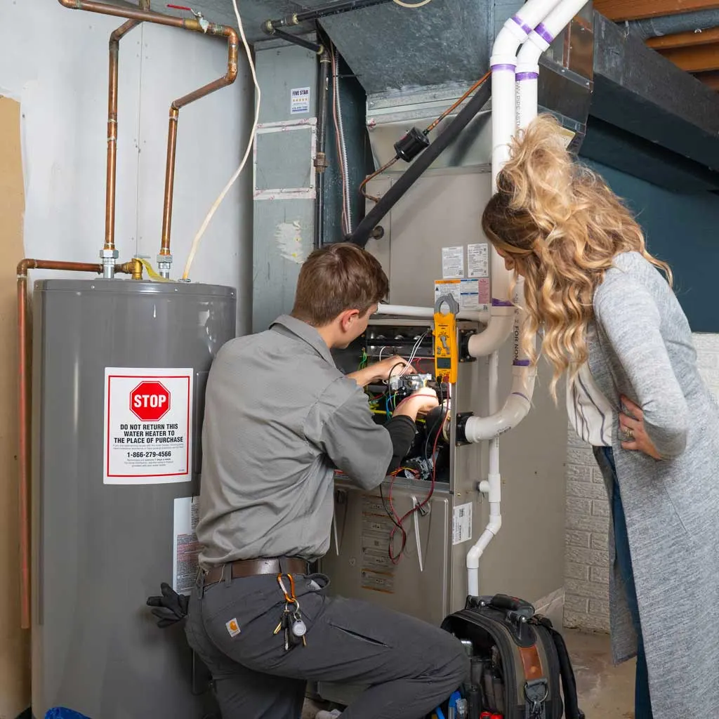 furnace technician showing homeowner their furnace